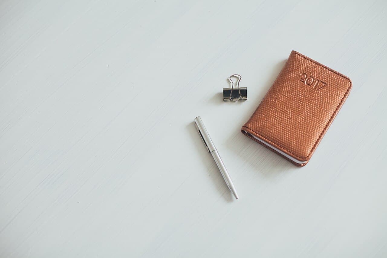 Brown leather notebook with a pen on a light desk